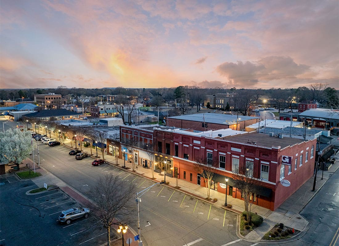 Conway, AR - Aerial View of the Ott Insurance LLC Building Next to Other Commercial Buildings in Downtown Conway Arkansas in the Evening